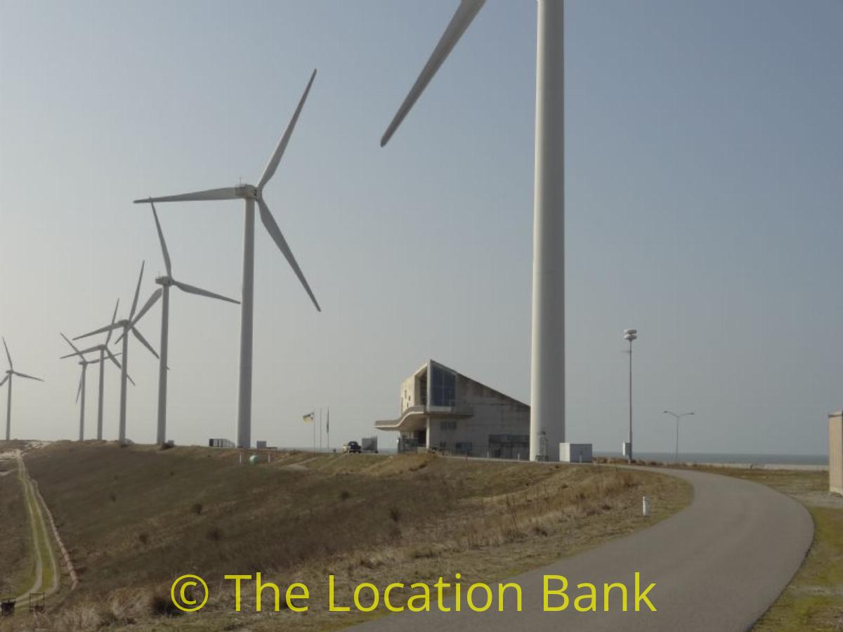 Modern betonnen Gebouw tussen windmolens