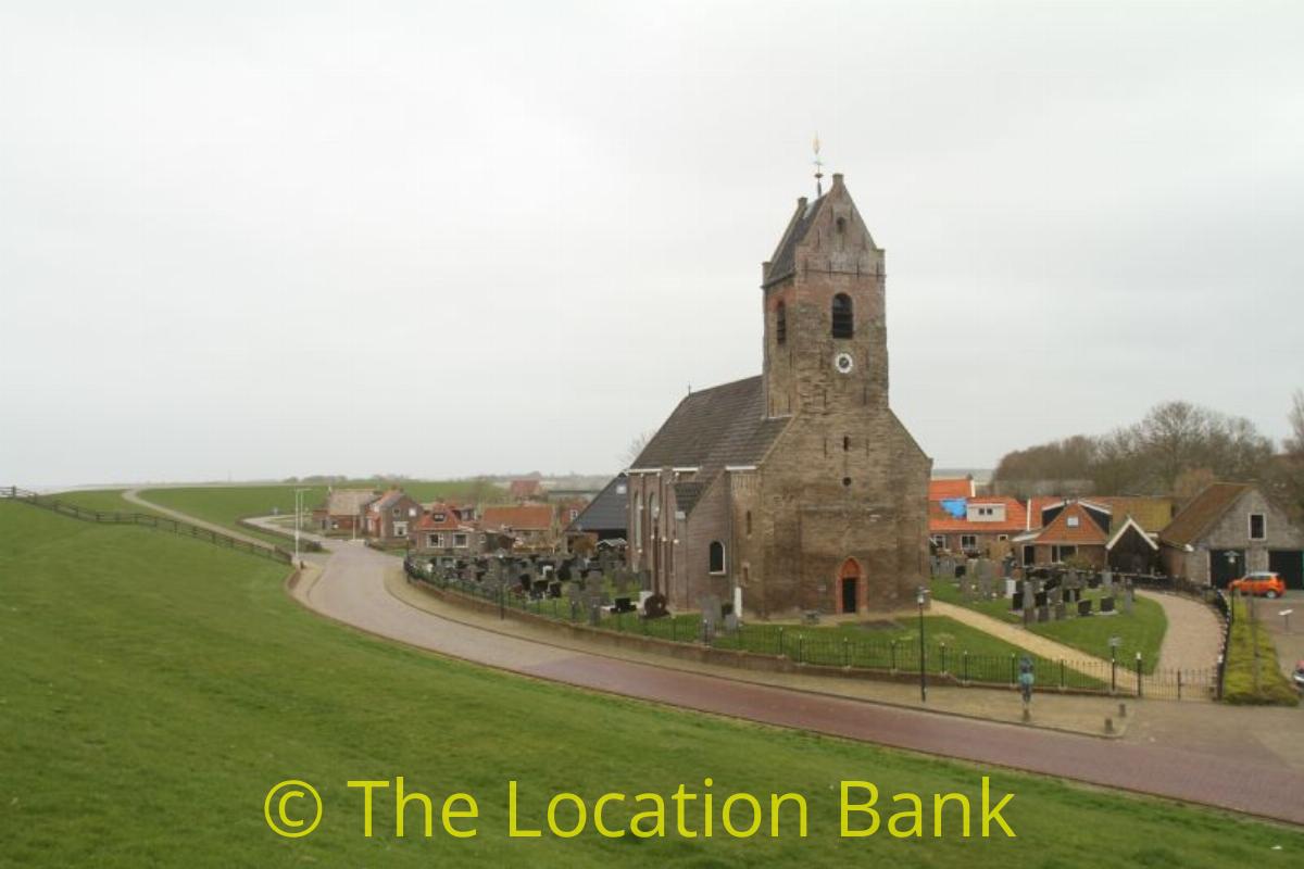 kerk met begraafplaats langs weg en dijk 