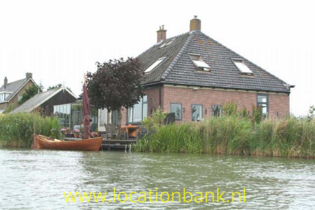 Boerderij aan het water met boot aan steiger