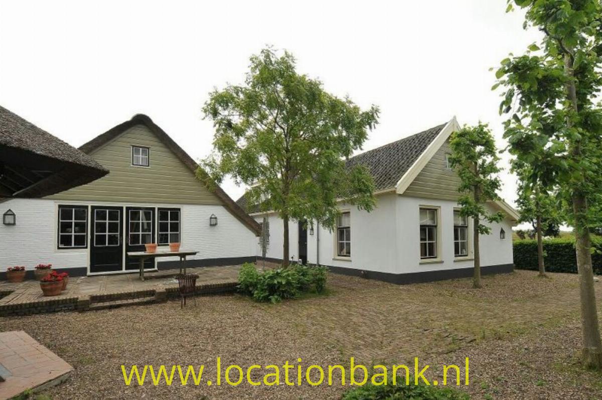 woonboerderij en villa aan een rivier