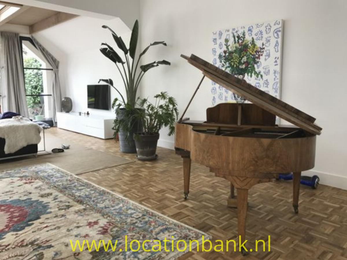 woonkamer met parketvloer en piano