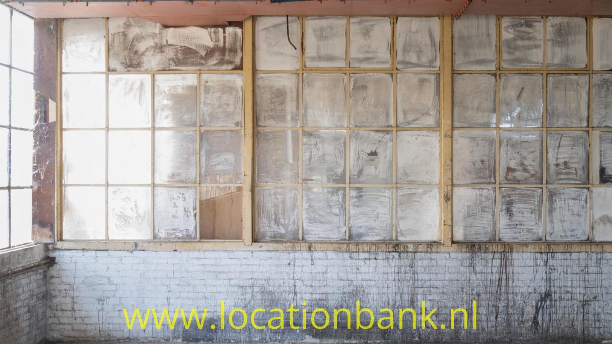 Urbex 1: oude industriële ruimtes op de derde verdieping, met invallend daglicht door grote ramen aan weerszijden van het gebrouw.