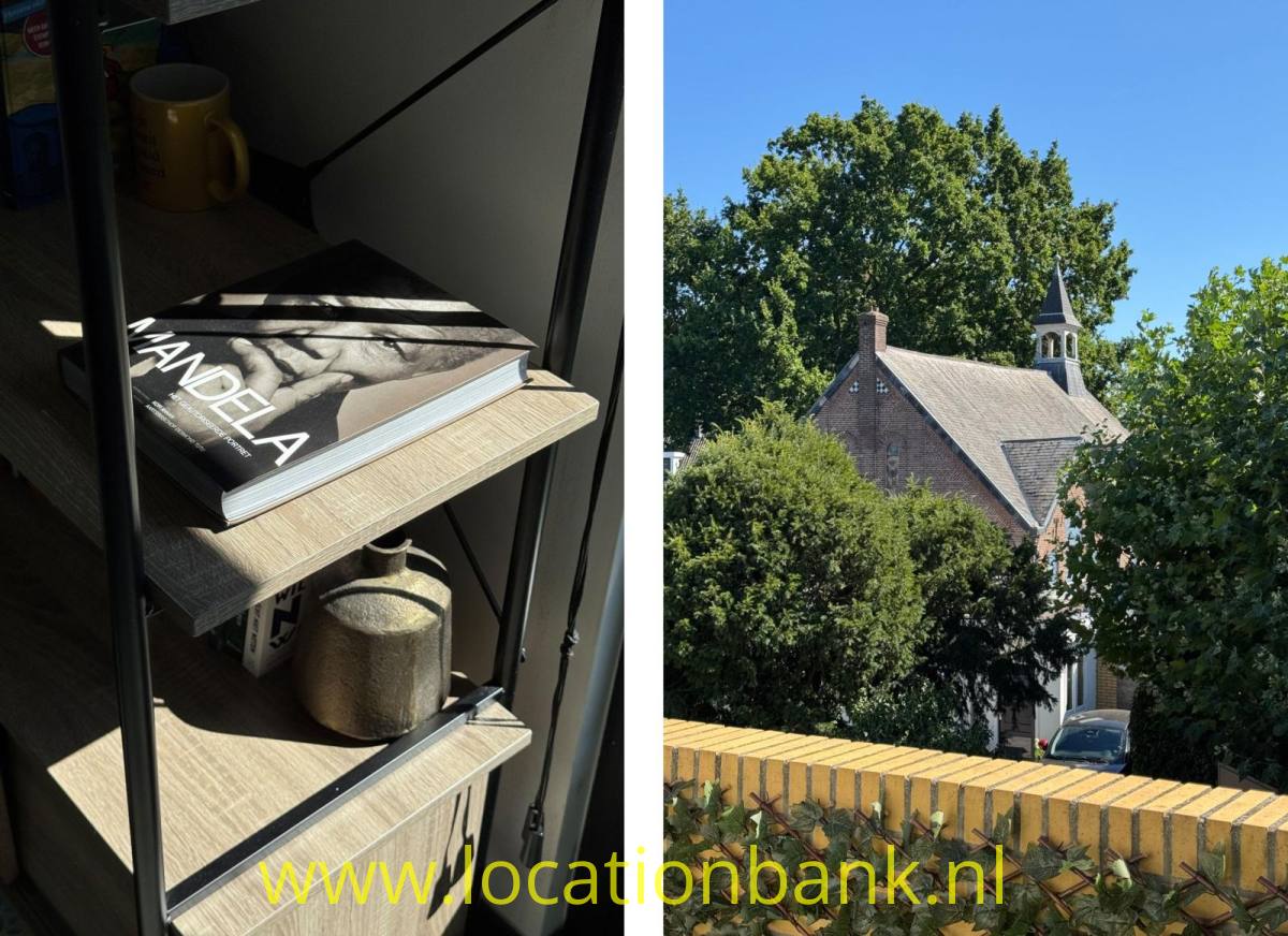 Ein offenes Regal mit Büchern und einer Tasse, daneben einer Kirche mit Turm, Bäumen und einer Ziegelmauer.