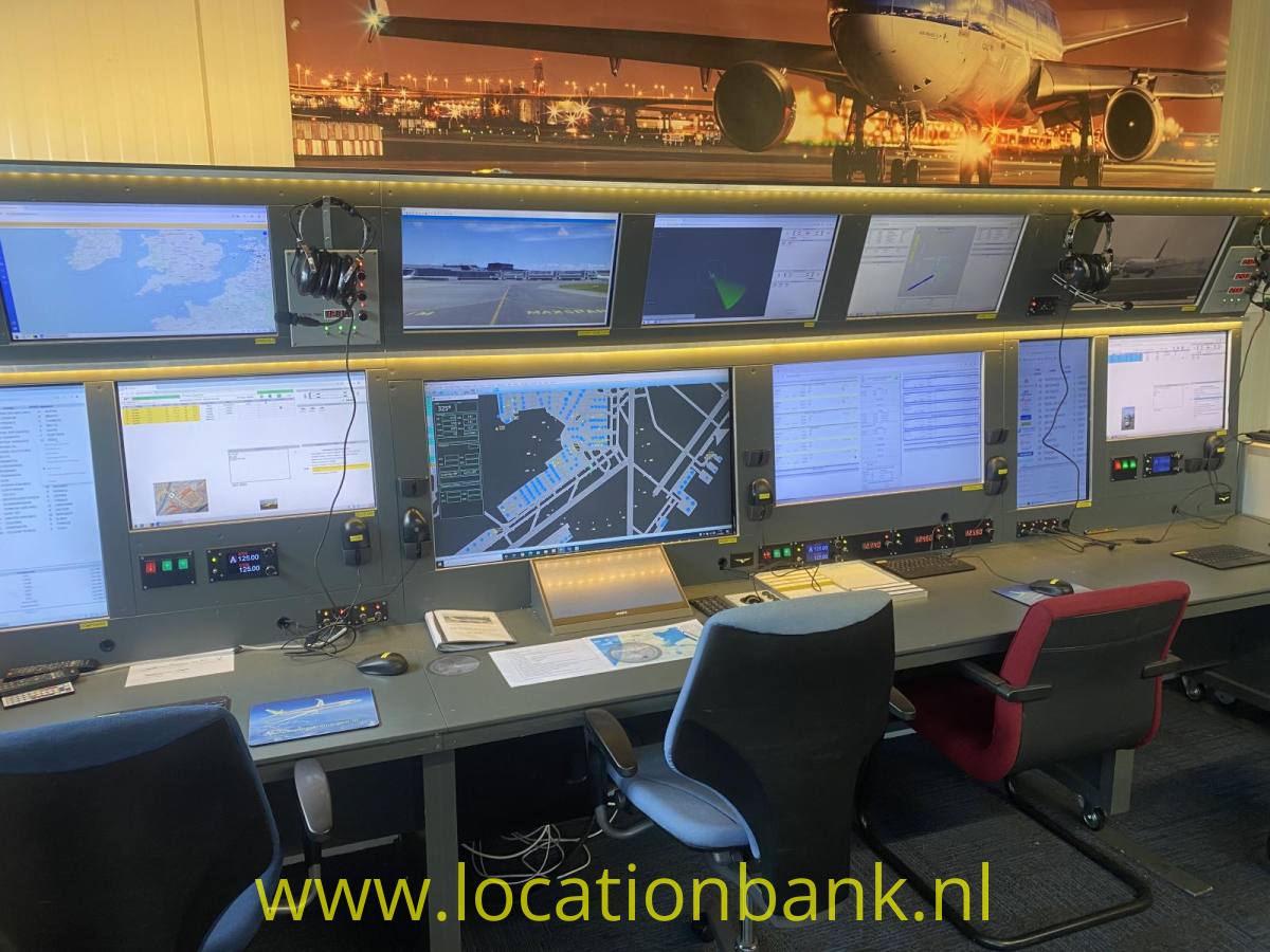 Luft Verkehrs Leitung mit mehreren Computerbildschirmen, Bedienfeldern und Bürostühlen unter einem großen Flugzeugbild.