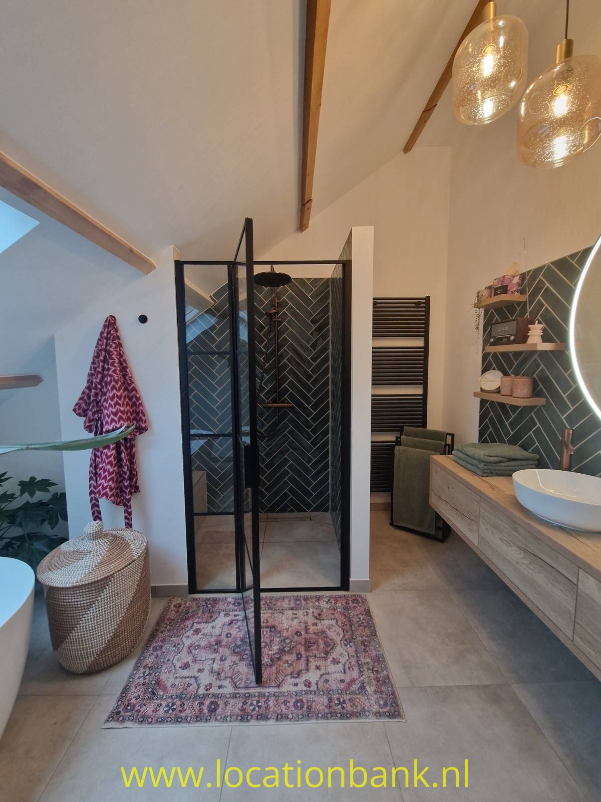 Badezimmer mit einer Glasdusche mit schwarzem Rahmen, einem Waschtischunterschrank und einer freistehenden Badewanne.