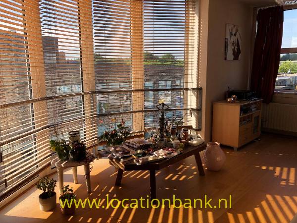 filmlocatie appartement Amsterdam Modern scheepvormig appartement in Amsterdam Noord met divers decor en uitzicht op een marktplein