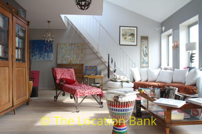 Living room with staircase and white wall