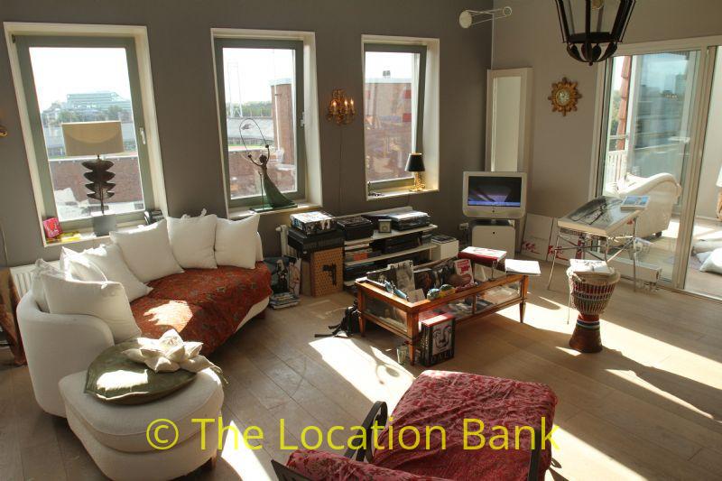 Fabric sofa in living room with 3 windows and glass doors.
