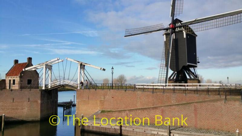 old wooden bridge and classic dutch windmill