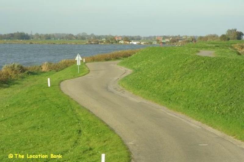 Rural road next to a dyke and water