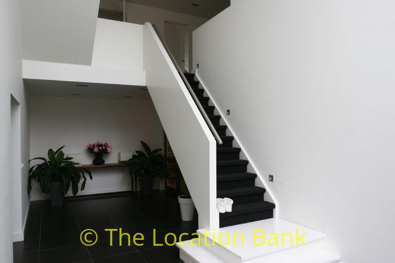 white hallway with stairs