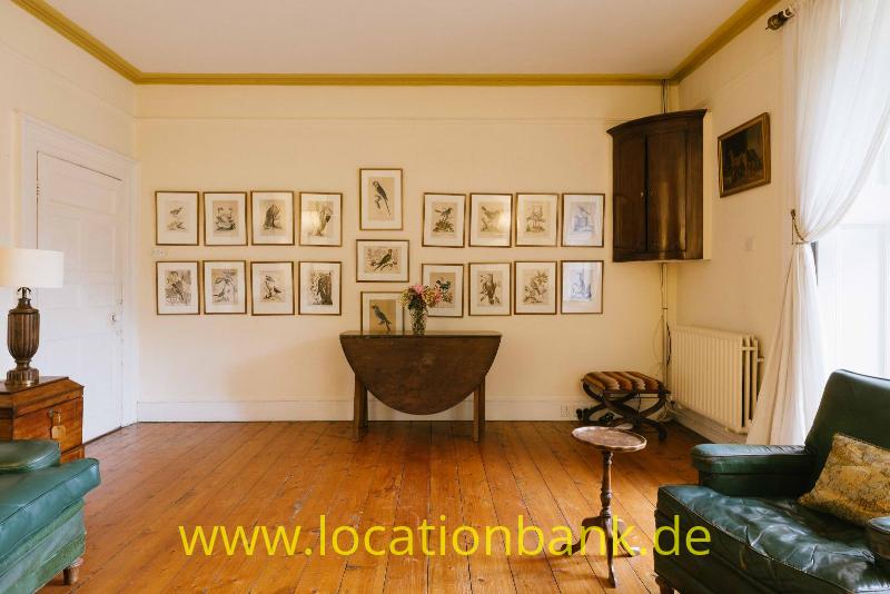 Wohnzimmer mit Gerahmte Drucke hängen an einer Wand über einem Holztisch in einem Raum mit Holzboden.