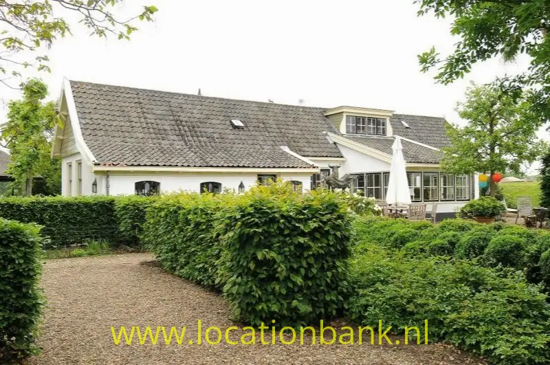 woonboerderij en villa aan een rivier