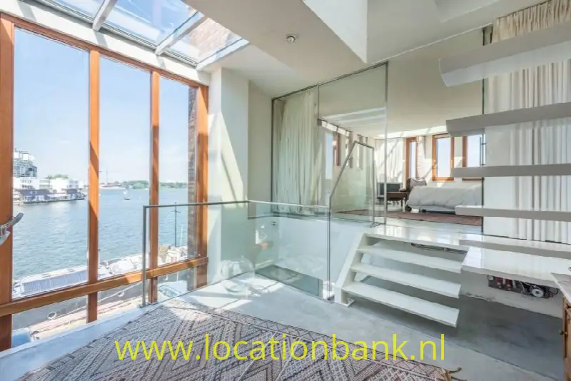 woonkamer met uitzicht over de Amsterdamse haven