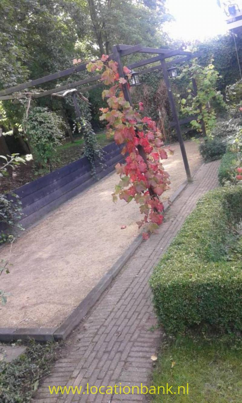 jeu de boules baan in tuin, grenzend aan sloot en kerk