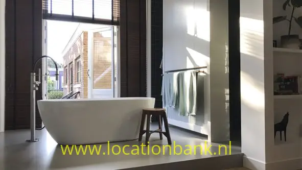 Badkamer in slaapkamer met los bad