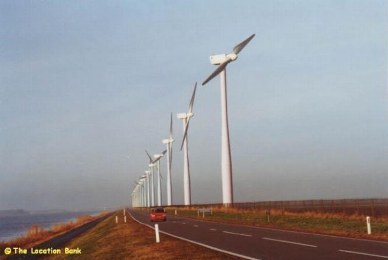 Weg met windmolens aan het water