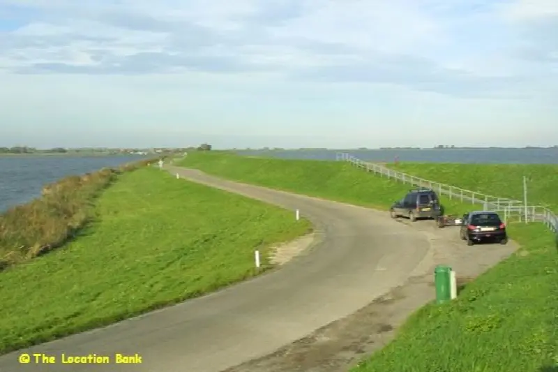 Landweg naast een dijk aan het water