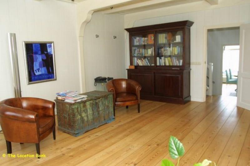 Huiskamer / woonkamer met houten vloer en doorkijk