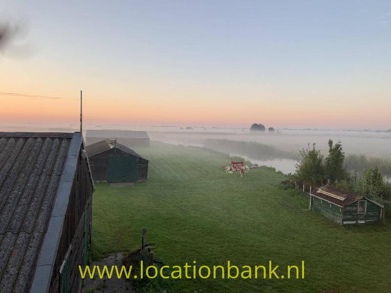 Uitzicht vanuit zolder in ochtendzon en dauw