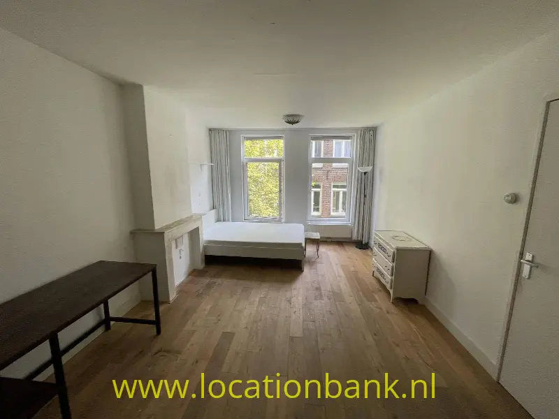 woonkamer/slaapkamer vanaf muurkant met uitzocht op binnentuin
