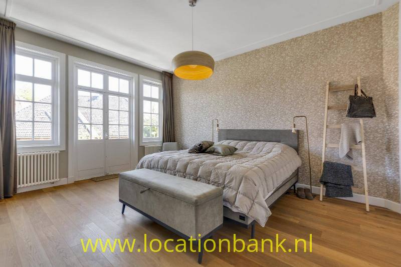 Master bedroom 1ste verdieping met openslaande deuren naar veranda.