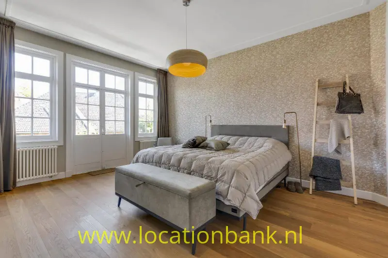 Master bedroom 1ste verdieping met openslaande deuren naar veranda.