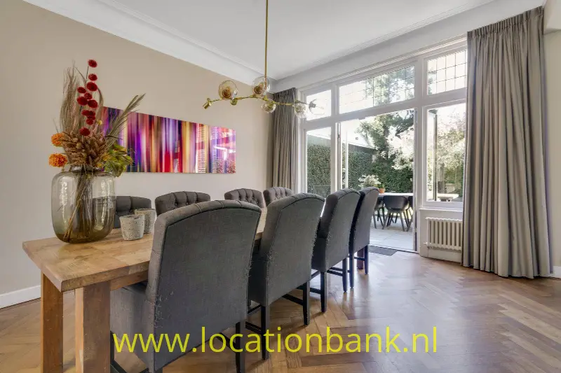 Achter/eetkamer gezien vanuit de keuken. Zie opslaande deuren naar de achtertuin.