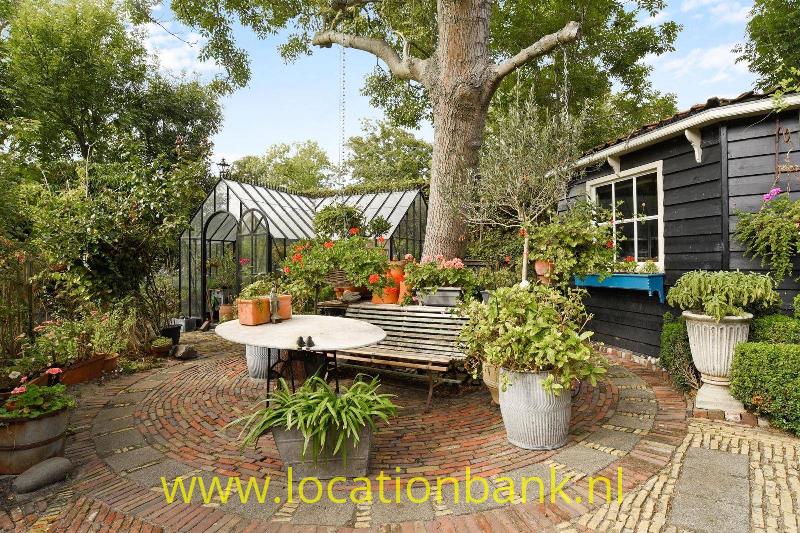 Tuin met kas en schuur.