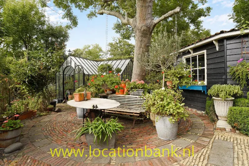 Tuin met kas en schuur.