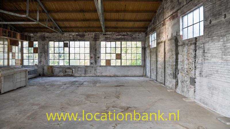 Urbex 1: oude industriële ruimtes op de derde verdieping, met invallend daglicht door grote ramen aan weerszijden van het gebrouw.