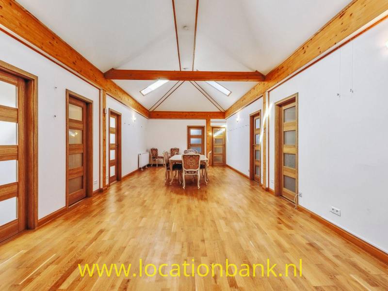 Ruime, sfeervolle landhuiszaal met karakteristieke houten dakconstructie, warme houten vloer en authentieke houten deuren. De hoge kap, dakramen en royale open ruimte zorgen voor een lichte en stijlvolle uitstraling. Een veelzijdige filmlocatie in Duitsland voor film, televisie, fotografie en commercials.