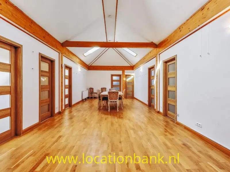 Ruime, sfeervolle landhuiszaal met karakteristieke houten dakconstructie, warme houten vloer en authentieke houten deuren. De hoge kap, dakramen en royale open ruimte zorgen voor een lichte en stijlvolle uitstraling. Een veelzijdige filmlocatie in Duitsland voor film, televisie, fotografie en commercials.