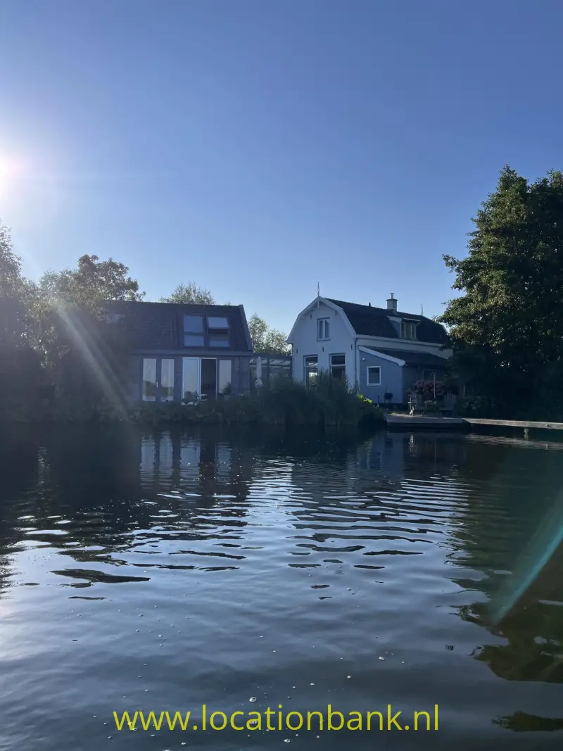Huis gezien vanaf het water huis met riet aan de oever 