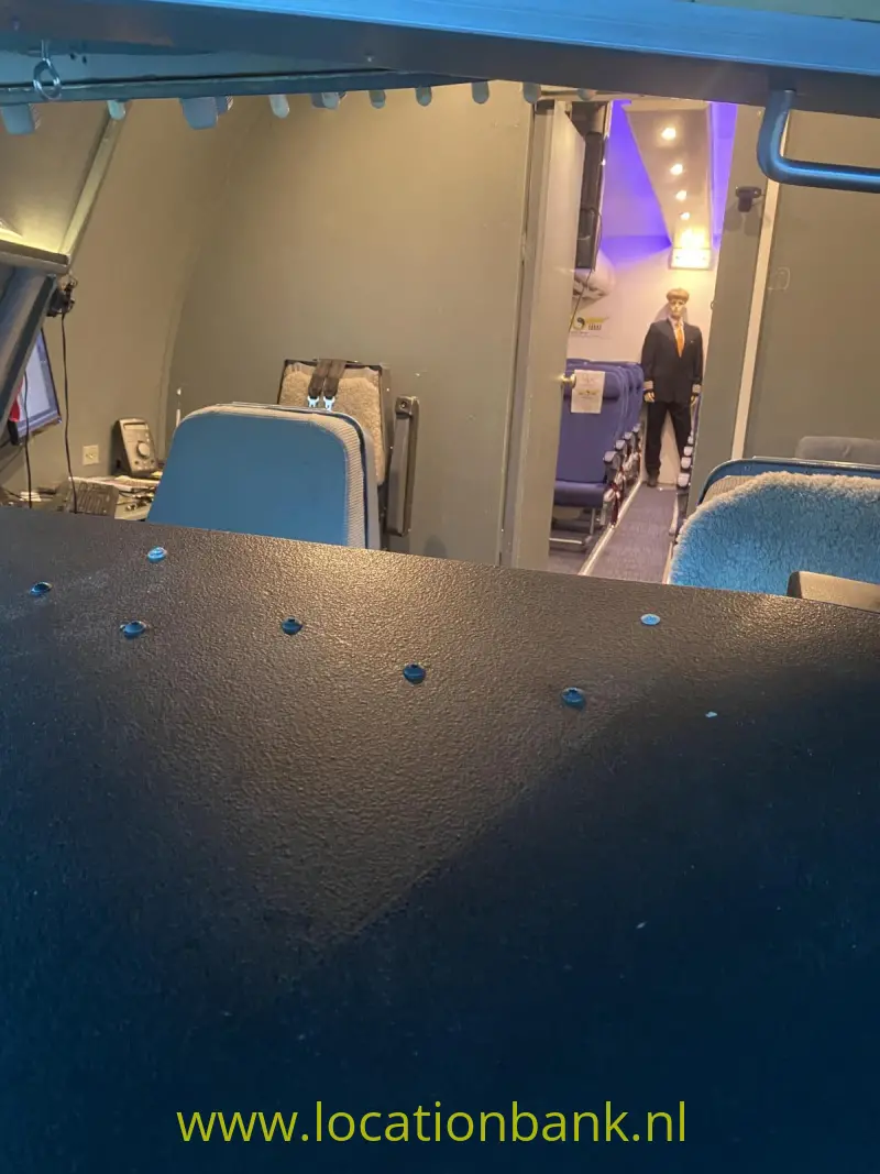 Vliegtuig cockpit Blauw beklede stoelen en een persoon zijn zichtbaar in een verlichte passagiers cabine.