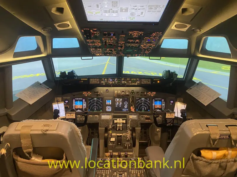 De cockpit van een vliegtuig met verlichte instrumentenpanelen en een startbaan zichtbaar door de voorruiten.