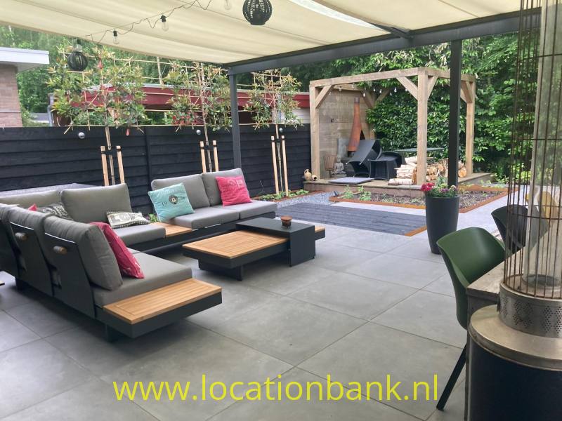 Overdekt terras met modulaire loungebanken, lage houten tafels, plantenbakken en een houten overkapping.