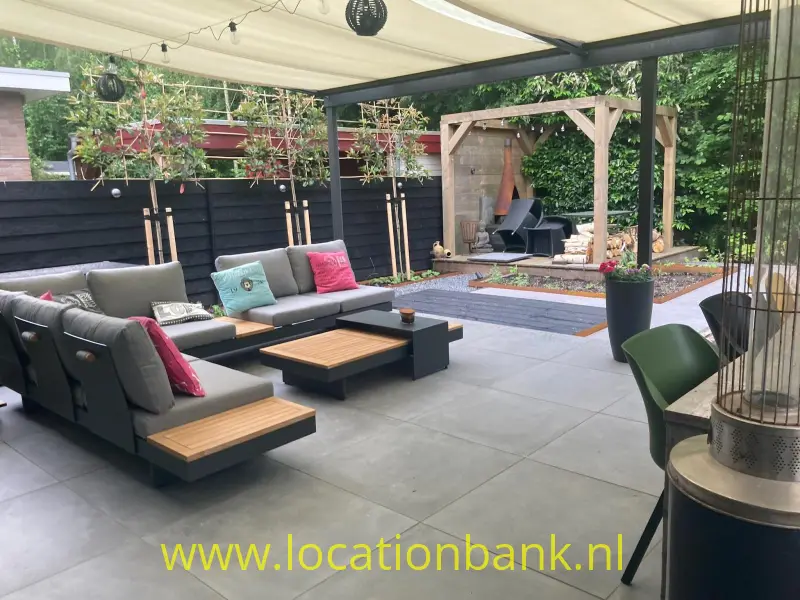 Overdekt terras met modulaire loungebanken, lage houten tafels, plantenbakken en een houten overkapping.