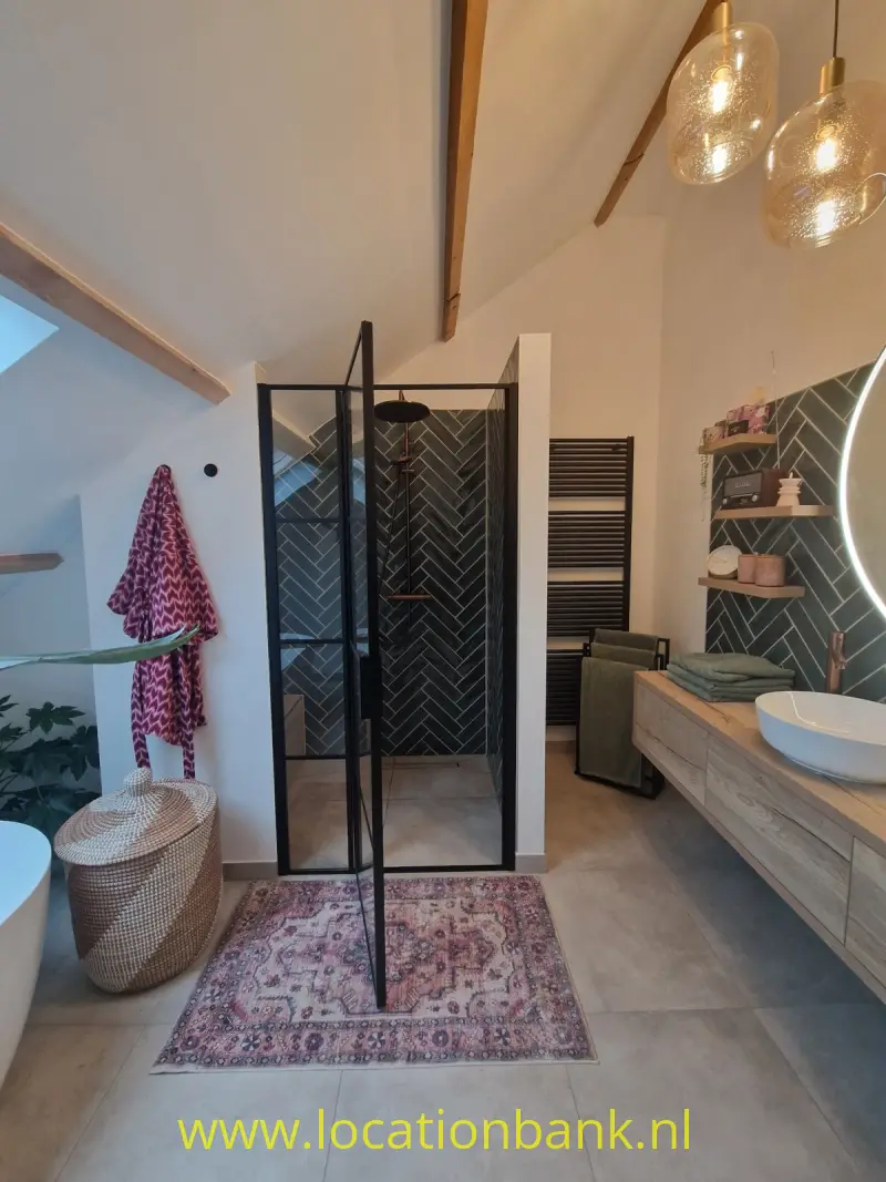Badkamer met een glazen inloopdouche met zwart frame, een wastafelmeubel en een vrijstaand ligbad.