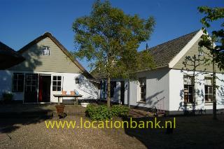 woonboerderij en villa aan een rivier