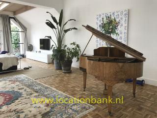 woonkamer met parketvloer en piano