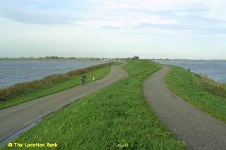 Landweg naast een dijk aan het water