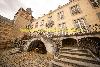 Gebäude aus hellem Stein mit einem Rundbogendurchgang,Stattliche Treppe, verzierten Eisengeländern, einer Kopfsteinpflasterstraße.