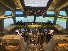 Das Cockpit eines Flugzeugs mit beleuchteten Instrumententafeln und einer durch die Frontfenster sichtbaren Startbahn.