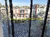 Balkon mit Topfpflanzen und einem Metallgeländer mit Blick auf angrenzende Stadthäuser.