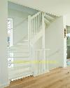 Weiße Treppe mit offenen Stufen und senkrechten Geländerstäben führt von einem Holzboden nach oben.